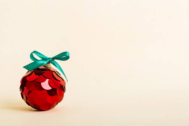 istock Christmas ball on colored background. decoration bauble with ribbon bow with copy space 1439537286