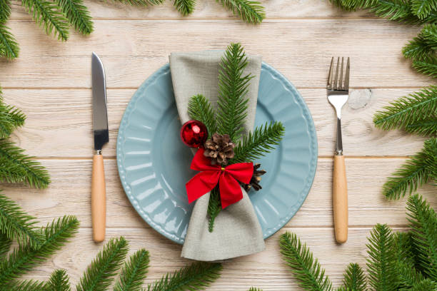 istock Christmas table place setting with christmas decor and plates, kine, fork and spoon. Christmas holiday background. Top view 1439537355