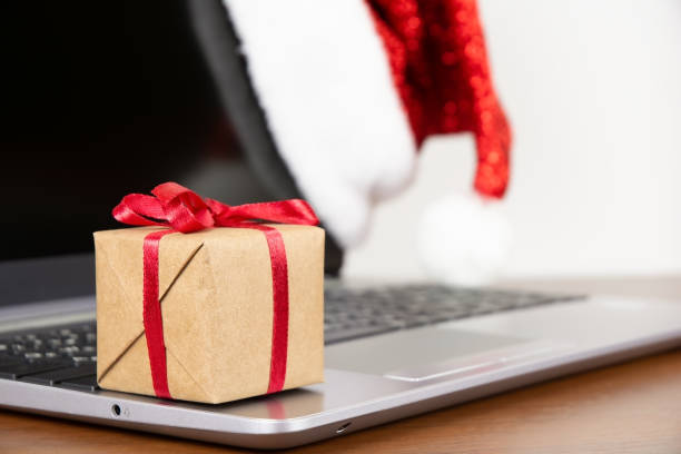 istock Gift box on laptop with santa hat 1439537585