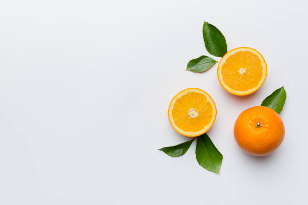istock fresh Fruit orange slices on colored background. Top view. Copy Space. creative summer concept. Half of citrus in minimal flat lay with copy space 1439537699