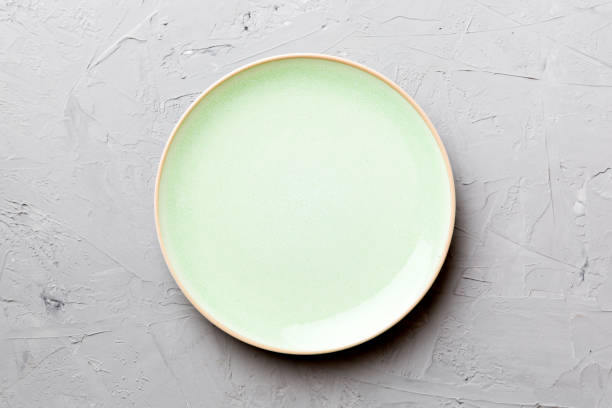 istock Top view of empty green plate on cement background. Empty space for your design 1439537722