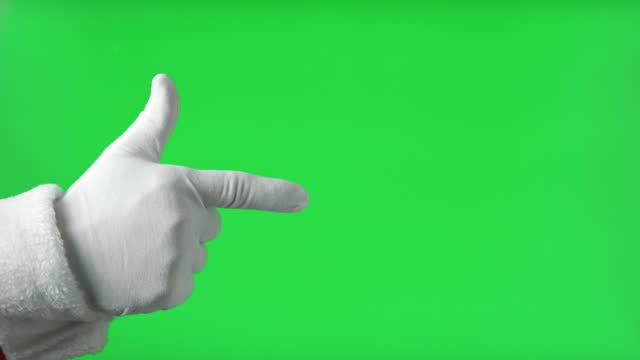 Santa Claus Hand Pointing to the Front with Index Finger Isolated On Green Background. Close Up. White Gloved Hand Points Forward at Something with one finger. Chroma Key Screen. Advertisement gesture