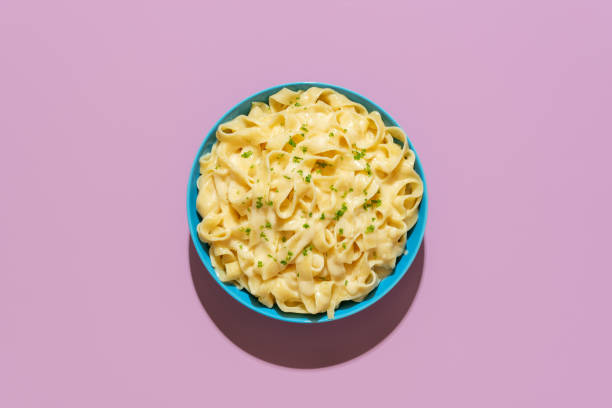 pasta fettuccine alfredo above view on a purple background - blue plate fotos imagens e fotografias de stock