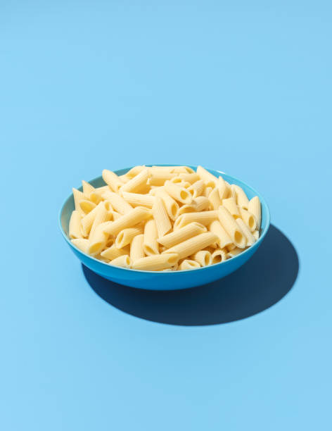 istock Penne pasta bowl minimalist on a blue background 1439539823