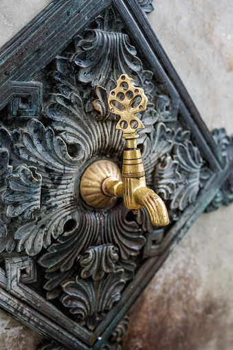Istanbul, Turkey-August 10, 2022: Close-up shot of brass faucets and bronze floral carvings around the historical German Fountain in Sultan Ahmet Square. Shot with Canon EOS R5.