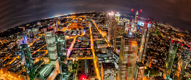 The skyline with the houses and streets of Frankfurt am Main at night and artificial lighting