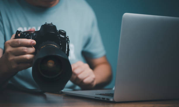 istock Young man learning to use and setting DSLR camera from video online course. 1439543365
