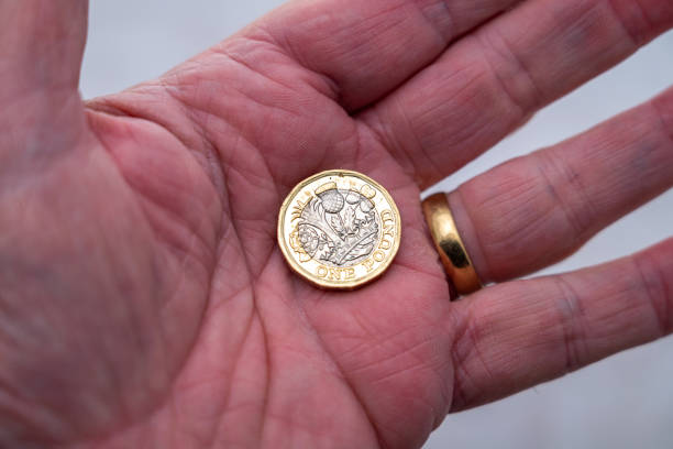 男の手に1ポンド硬貨 - one pound coin coin currency british culture ストックフォトと画像