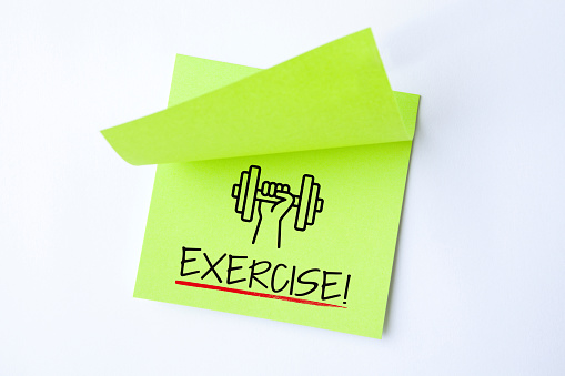 Green Sticky Note With Exercise And Red Push Pin On White Background