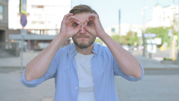 istock Outdoor Young Man Searching with Handmade Binocular 1439546049