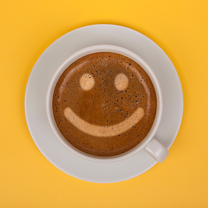 Coffee cup with smiley face on wooden table