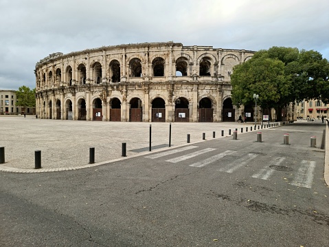 The Arena of Nîmes is a Roman amphitheatre, situated in the French city of Nîmes. Built around 70 CE, shortly after the Colosseum of Rome, it is one of the best-preserved Roman amphitheatres in the world. The image was captured during autumn season.