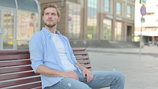 Waiting Middle Aged Man Sitting on Bench Outdoor