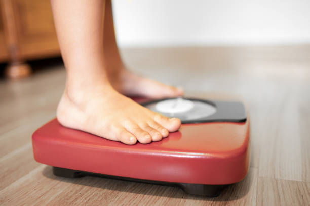 istock kid on the weight scale 1439550781