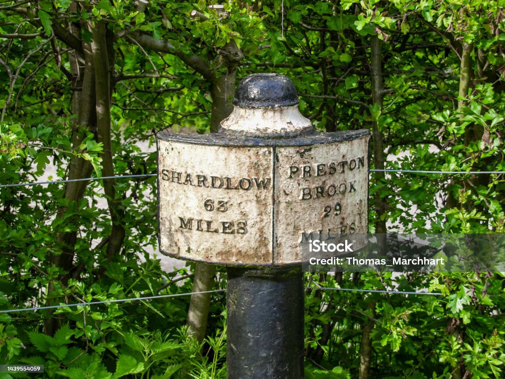 Milepost near Stoke-on-Trent Cast iron signpost on the Trent and Mersey Canal near Stoke-on-Trent in England showing the distance to Shardlow and Preston Brook. Black Color Stock Photo