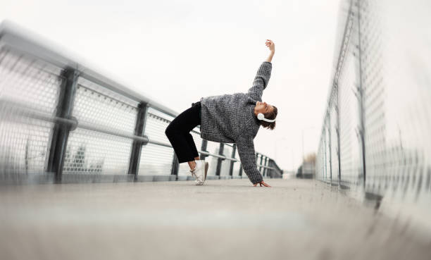 istock Young woman dances outdoors listening music. 1439554314