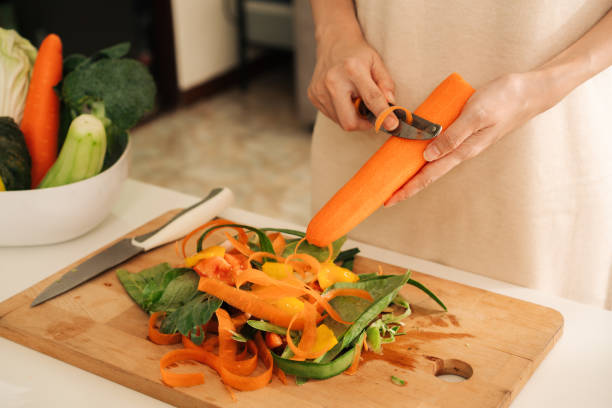 mujer sobras compost mezcla de ingredientes verduras y frutas en casa. - carrot close up silverware cutting board fotografías e imágenes de stock