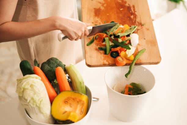 mujer sobras compost mezcla de ingredientes verduras y frutas en casa. - carrot close up silverware cutting board fotografías e imágenes de stock