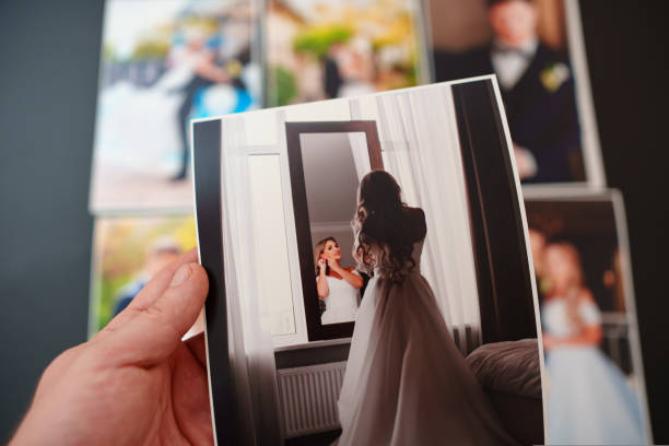 istock printed wedding photos on a black background and in hand. 1439556216