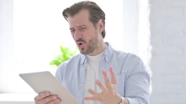 istock Young Man having Loss on Tablet in Office 1439556234