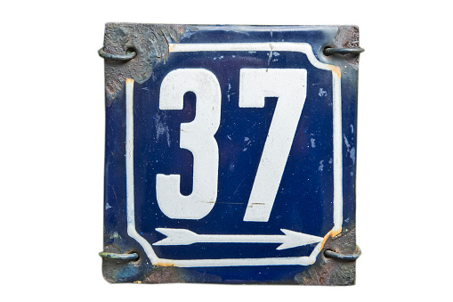 Weathered grunge square metal enameled plate of number of street address with number 37 isolated on white background