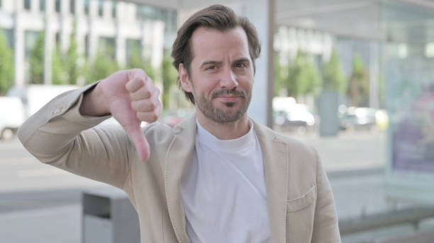istock Thumbs Down By Young Man Standing Outdoor 1439562261