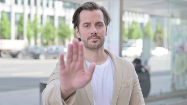 istock Stressed Young Man Showing Stop Gesture, Outdoor 1439562549