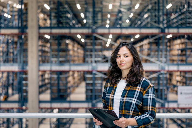 Portrait of young woman warehouse supervisor with a clipboard stock photo