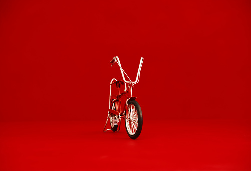 Small red bike against a red background with space for text