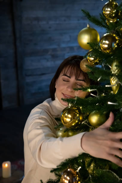 istock happy woman hugs Christmas tree 1439578384