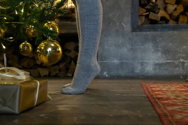 istock Woman stands tiptoe by Christmas tree 1439578471