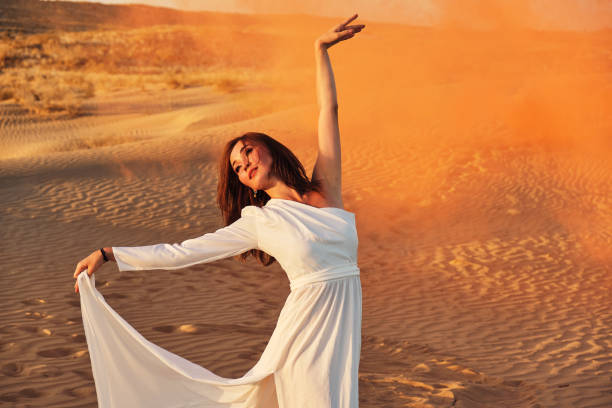 istock Dances in the desert in white dress 1439579646