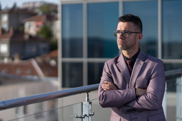 istock Handsome mature manager with arms crossed standing in modern office 1439580231