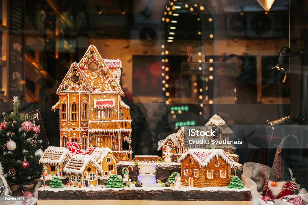 Gingerbread houses in urban holiday showcase. Christmas concept Gingerbread houses in urban holiday showcase, evening lights, reflections. Christmas concept Gingerbread House Stock Photo