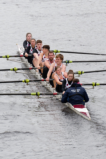 A team of eight racing in a rowing boat on the river Wear in Durham, England.