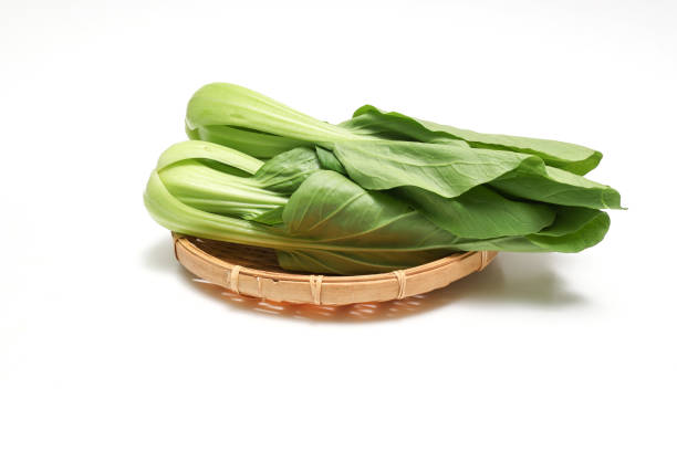 Bok choy on a bamboo colander isolated on a white background.