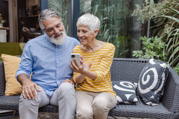 istock Happy senior couple relaxing and using smart phone on the balcony 1439592734