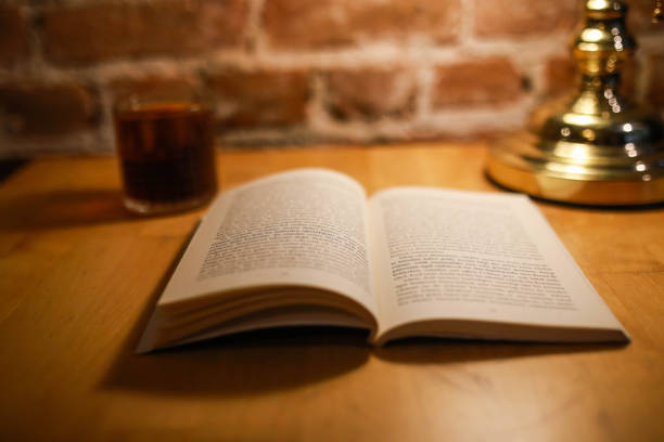 istock An open book, filter coffee cup and green table lamp background brick pattern. book reading concept 1439594740