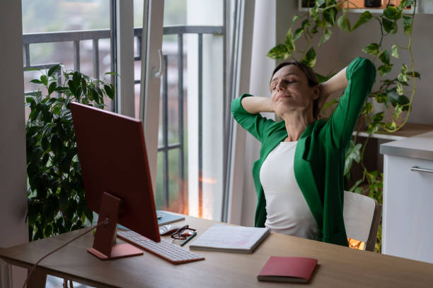 istock Optimistic business woman stretch hand up after completing difficult project sits at office table 1439594808