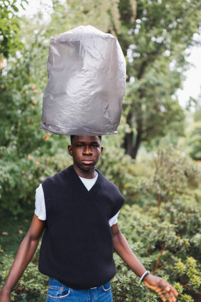 istock Young African man with plastic over head. Plastic pollution concept 1439597186