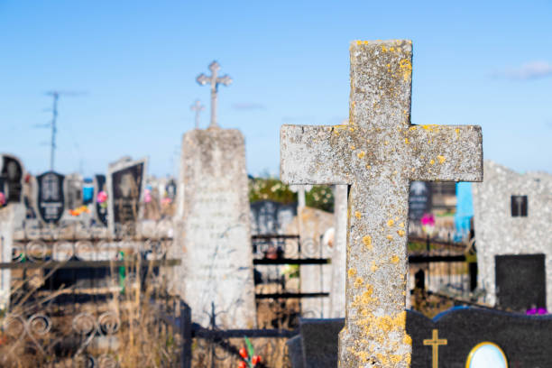 gravestone cross in cemetery with moss, concept - cemetery tombstone grave old imagens e fotografias de stock