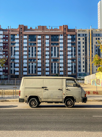 Valencia, Spain - September 5, 2022: Side view of weathered minivan parked in front of buildings. This kind of vehicles are used a lot by transport companies to move merchandise all around the city