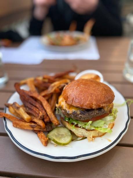 istock Regular Cheeseburger and Fries with a Pickle - Eating Out 1439604563