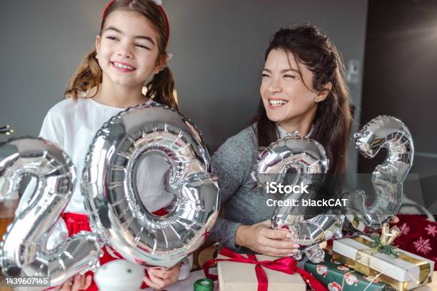 Mother And Daughter Holding Balloons In The Shape Of Numbers 2023 And Celebrating New Year Stock Photo - Download Image Now