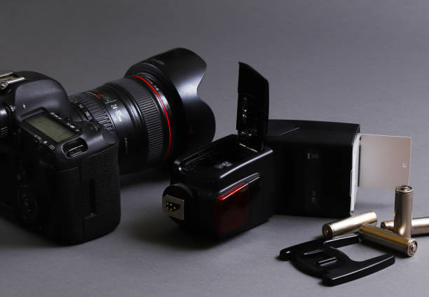 istock Photojournalist's desk. On-camera flash with a digital camera on a gray background 1439608541