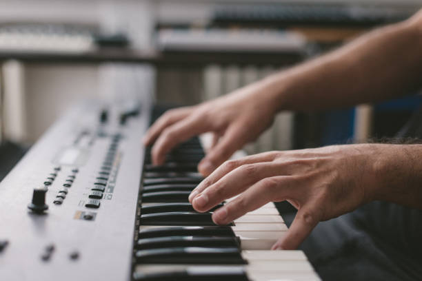 istock Close-Up Of Hands playing electronic piano keyboards 1439610736