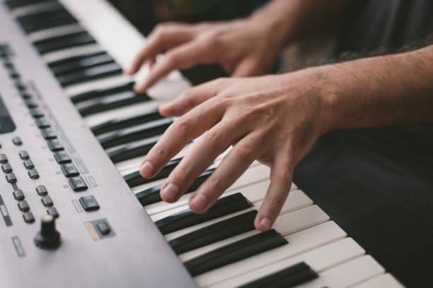 istock Close-Up Of Hands playing electronic piano keyboards 1439610811