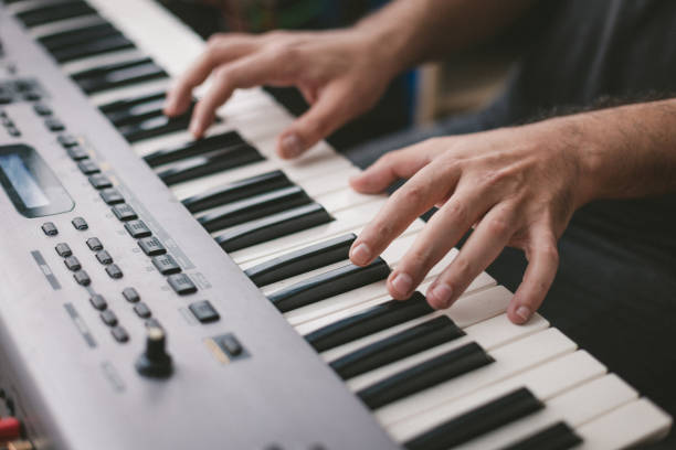 istock Close-Up Of Hands playing electronic piano keyboards 1439610819
