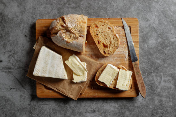Ciabatta bread and brie cheese on wooden cutting board