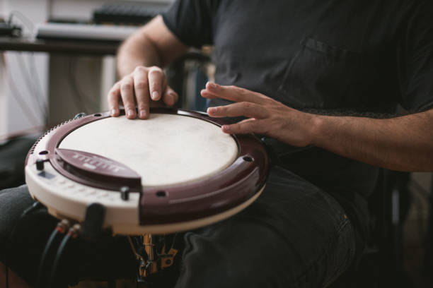 istock Young musician playing wavedrum percussion instrument in home music studio 1439610917